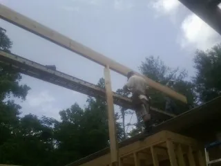 Carpenter setting a ridge beam over a new addition frame — Ice Dam Removal by Roofing Brothers in Lore City