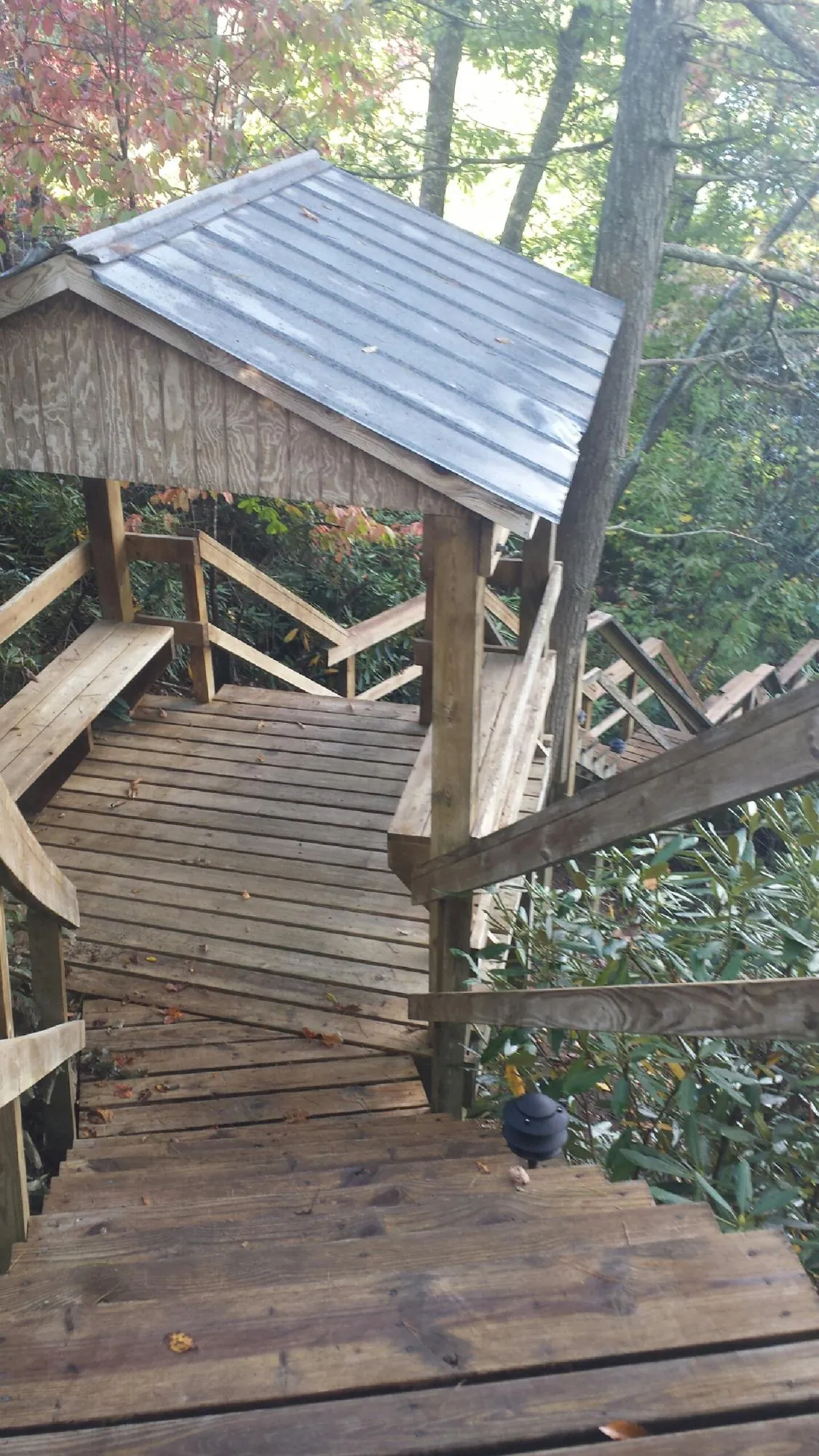 Metal roofed shelter over wooden steps on a wooded walkway — Skylight Repair & Installation work by our crew in Lore City