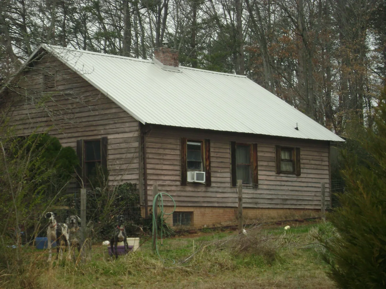 White metal roof on an old wood sided farmhouse, from a Metal Roof Installation job in Lore City